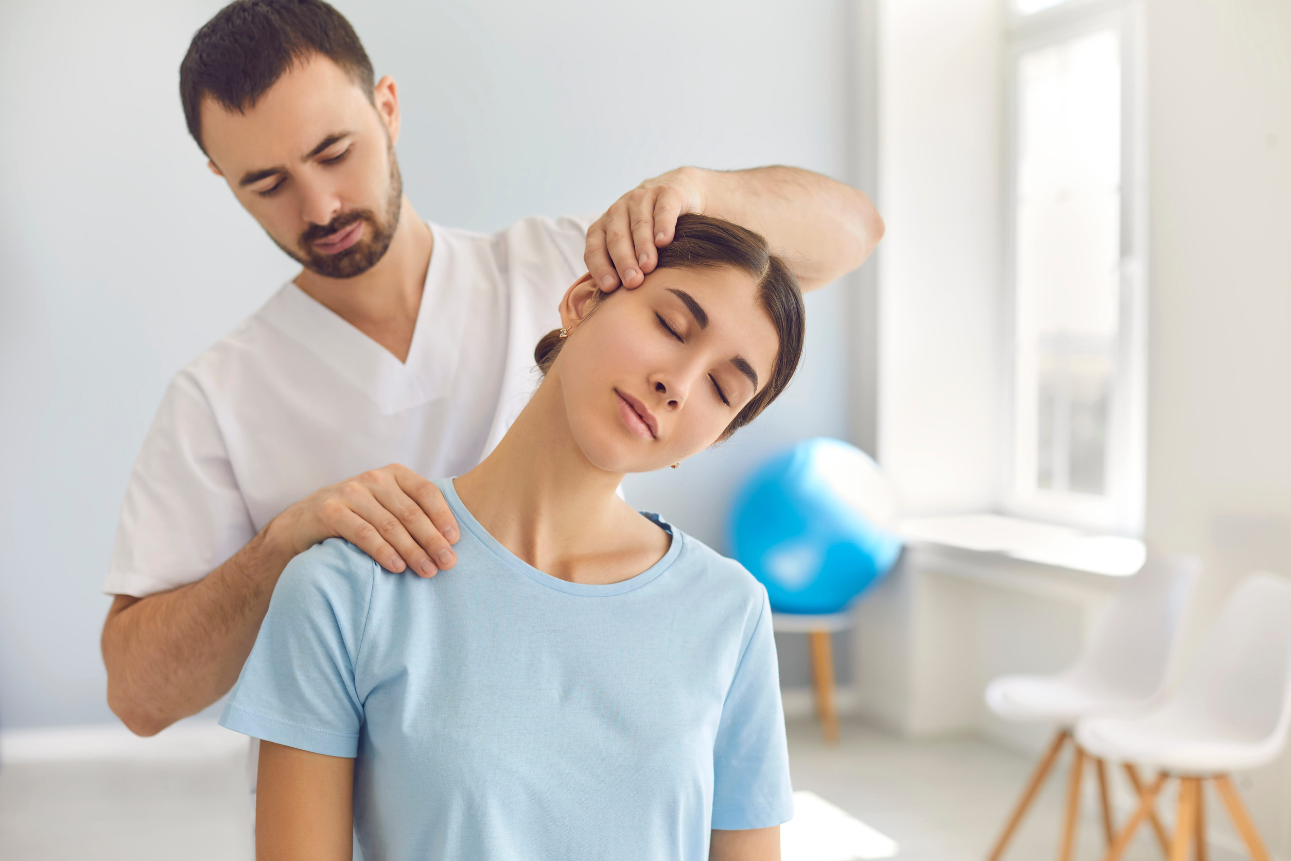 Chiropraticien pratiquant une évaluation cervicale sur une patiente ayant une douleur